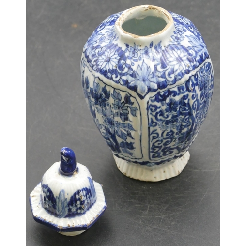 58 - A small Delft blue and white round bulbous thin necked lidded vase with allover floral, leaf and scr... 