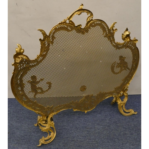 629 - A gilt metal scallop shaped fire screen with carrying handle and allover raised cupid, floral and sc... 