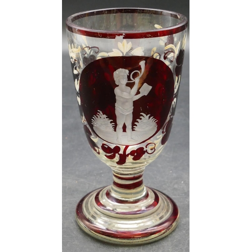 64 - A ruby and clear glass goblet with etched figure and painted floral decoration on round sweeping bas... 