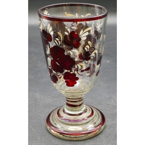 64 - A ruby and clear glass goblet with etched figure and painted floral decoration on round sweeping bas... 