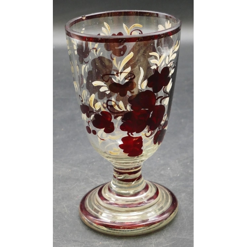 64 - A ruby and clear glass goblet with etched figure and painted floral decoration on round sweeping bas... 