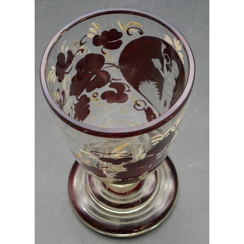 64 - A ruby and clear glass goblet with etched figure and painted floral decoration on round sweeping bas... 