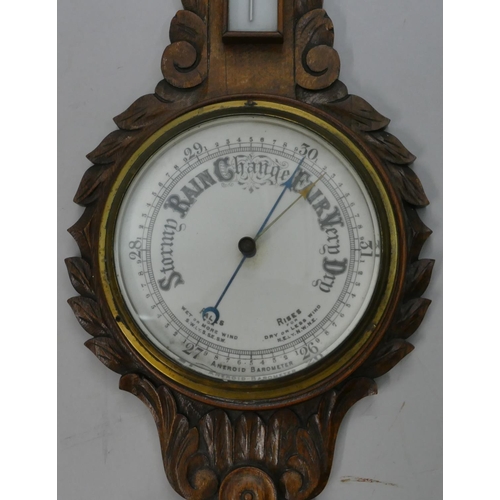 662 - A carved oak banjo barometer and thermometer with leaf and scroll decoration, 84cm high