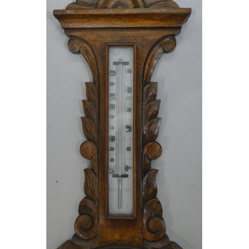 662 - A carved oak banjo barometer and thermometer with leaf and scroll decoration, 84cm high