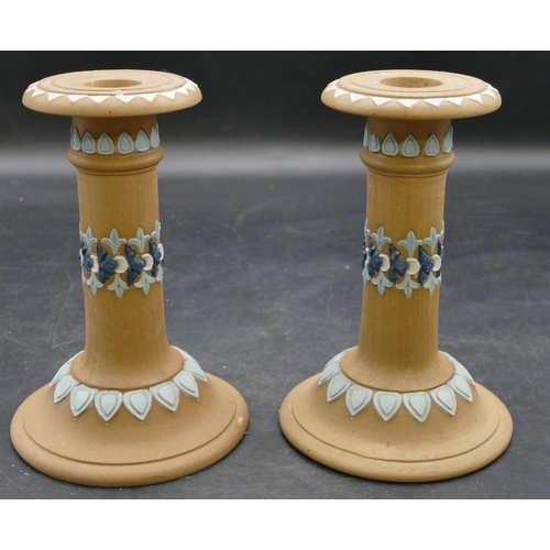 68 - A pair of Royal Doulton silicon candlesticks on round sweeping bases on brown ground with raised blu... 