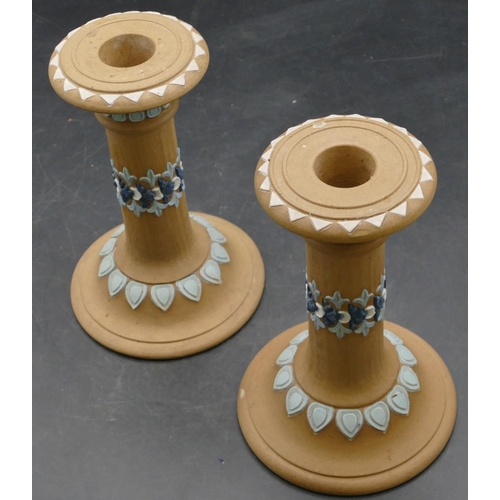 68 - A pair of Royal Doulton silicon candlesticks on round sweeping bases on brown ground with raised blu... 