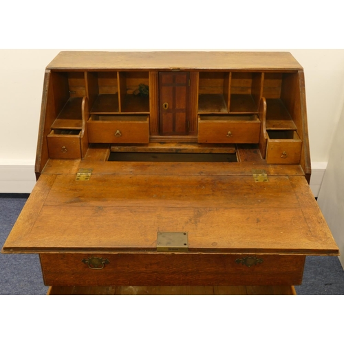 682 - An 18th Century small oak bureau with fall front, enclosing well, panelled door, secret compartments... 