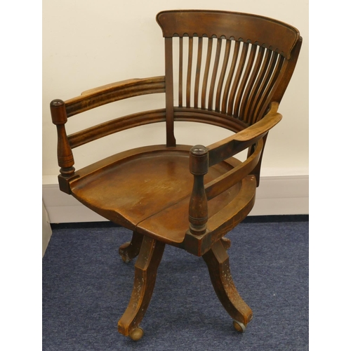 697 - An early 20th Century mahogany swivel desk chair with solid seat, spindle back, turned arms on 4 spl... 