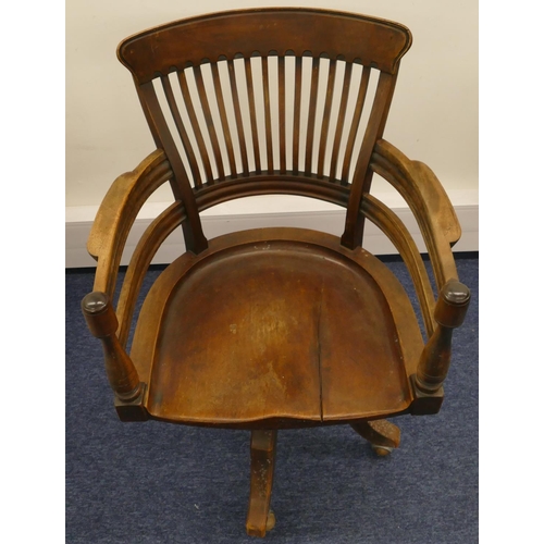 697 - An early 20th Century mahogany swivel desk chair with solid seat, spindle back, turned arms on 4 spl... 