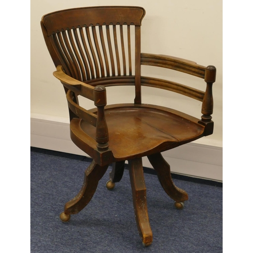 697 - An early 20th Century mahogany swivel desk chair with solid seat, spindle back, turned arms on 4 spl... 