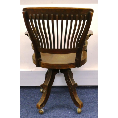 697 - An early 20th Century mahogany swivel desk chair with solid seat, spindle back, turned arms on 4 spl... 