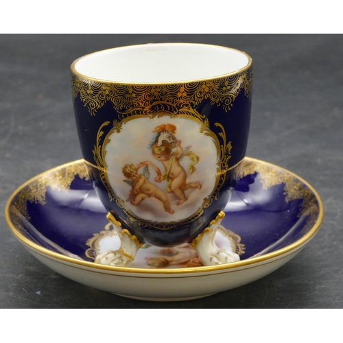 70 - A Meissen cabinet cup and saucer on royal blue ground with panels of cupids and allover gilt decorat... 