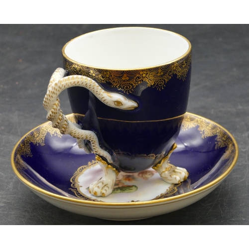 70 - A Meissen cabinet cup and saucer on royal blue ground with panels of cupids and allover gilt decorat... 