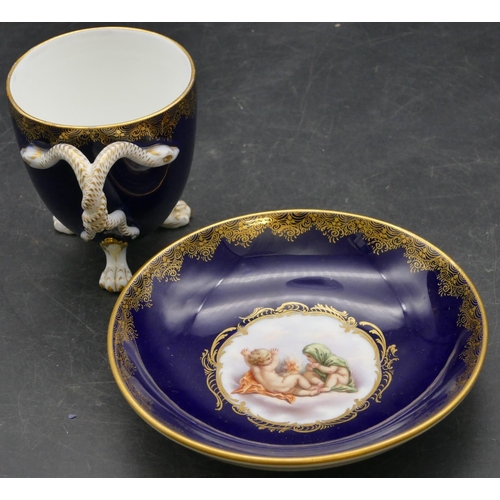 70 - A Meissen cabinet cup and saucer on royal blue ground with panels of cupids and allover gilt decorat... 