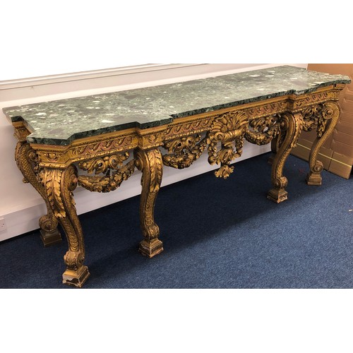 696 - An 18th Century and later carved gilt wood console table with green speckled marble top, carved frie... 