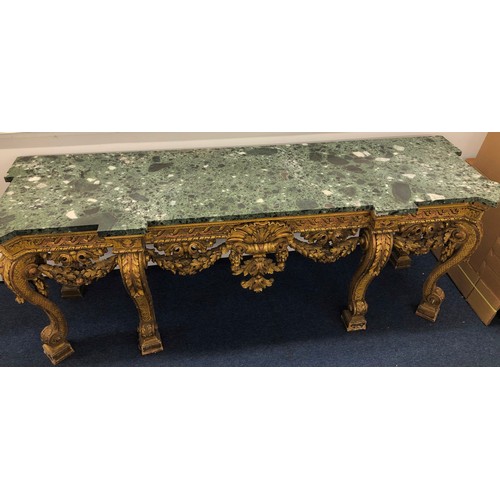 696 - An 18th Century and later carved gilt wood console table with green speckled marble top, carved frie... 