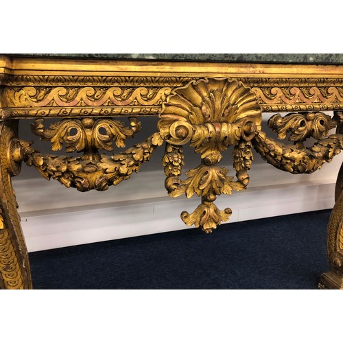 696 - An 18th Century and later carved gilt wood console table with green speckled marble top, carved frie... 