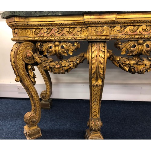 696 - An 18th Century and later carved gilt wood console table with green speckled marble top, carved frie... 