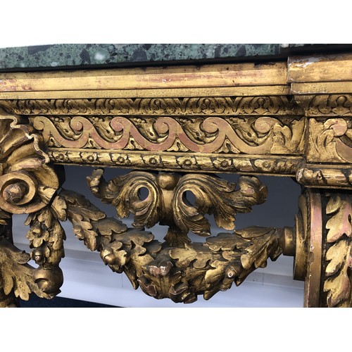 696 - An 18th Century and later carved gilt wood console table with green speckled marble top, carved frie... 