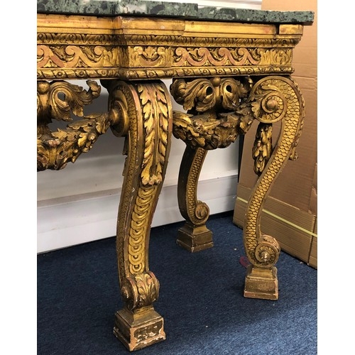 696 - An 18th Century and later carved gilt wood console table with green speckled marble top, carved frie... 