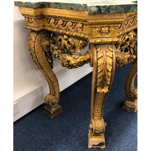 696 - An 18th Century and later carved gilt wood console table with green speckled marble top, carved frie... 