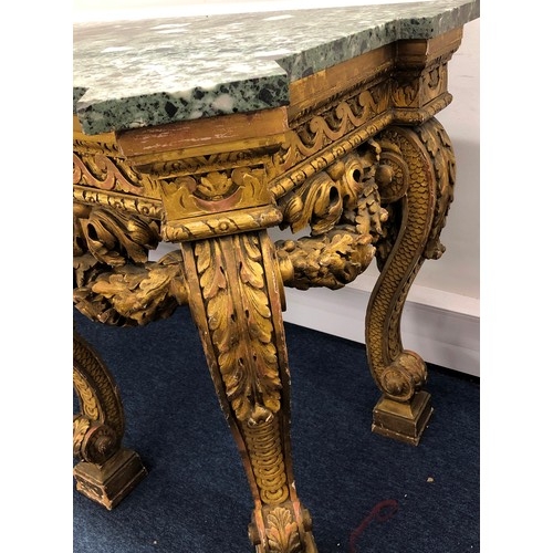 696 - An 18th Century and later carved gilt wood console table with green speckled marble top, carved frie... 