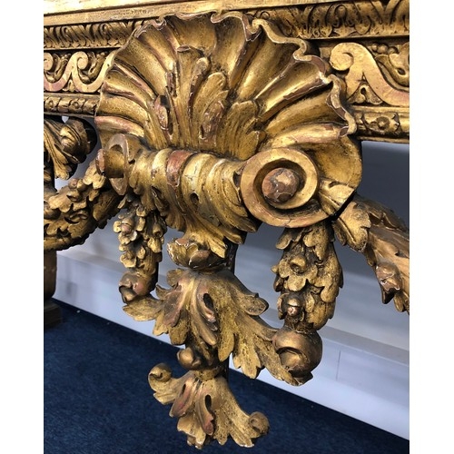 696 - An 18th Century and later carved gilt wood console table with green speckled marble top, carved frie... 