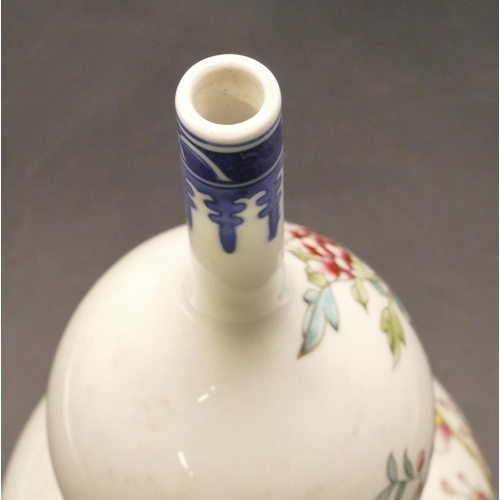 100 - An Oriental round gourd shaped vase on white and blue ground with multicoloured bird, branch and flo... 