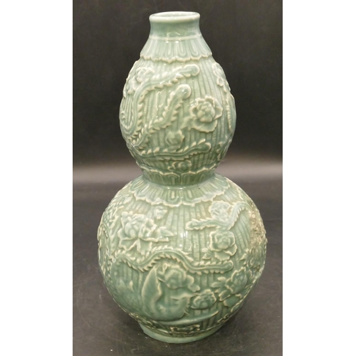 102 - An Oriental glazed earthenware gourd shaped vase on green ground with raised bird, floral and leaf d... 