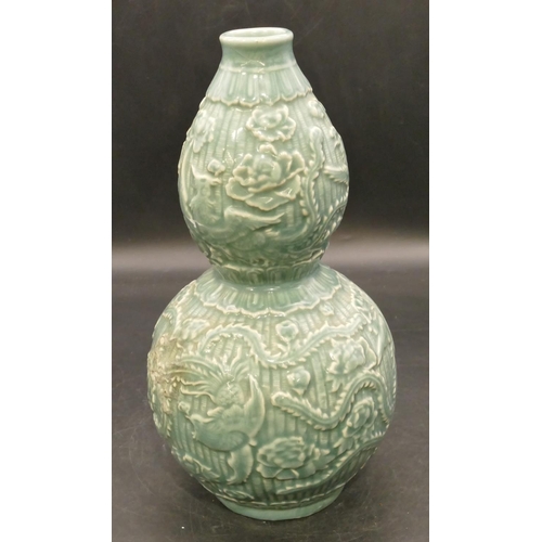 102 - An Oriental glazed earthenware gourd shaped vase on green ground with raised bird, floral and leaf d... 