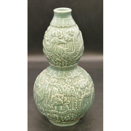 102 - An Oriental glazed earthenware gourd shaped vase on green ground with raised bird, floral and leaf d... 