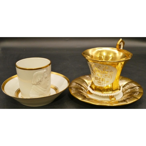 142 - A German porcelain cup and saucer on white and gilt ground with raised figurehead 