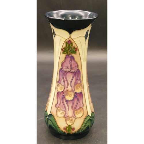 145 - A modern Moorcroft round trumpet shaped vase on green and cream ground with purple and green decorat... 