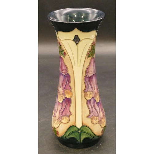 145 - A modern Moorcroft round trumpet shaped vase on green and cream ground with purple and green decorat... 