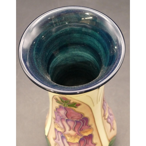 145 - A modern Moorcroft round trumpet shaped vase on green and cream ground with purple and green decorat... 