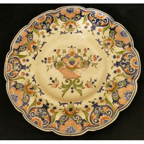 149 - A Delft round scalloped shaped dish on white ground with red, blue and green basket, floral, leaf an... 