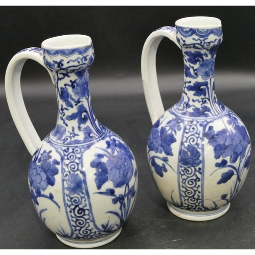 162 - A pair of Oriental blue and white bulbous thin necked jugs with allover floral, leaf and scroll deco... 