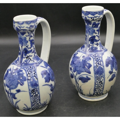 162 - A pair of Oriental blue and white bulbous thin necked jugs with allover floral, leaf and scroll deco... 