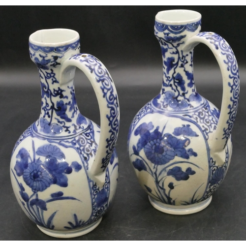 162 - A pair of Oriental blue and white bulbous thin necked jugs with allover floral, leaf and scroll deco... 