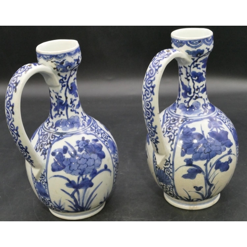 162 - A pair of Oriental blue and white bulbous thin necked jugs with allover floral, leaf and scroll deco... 