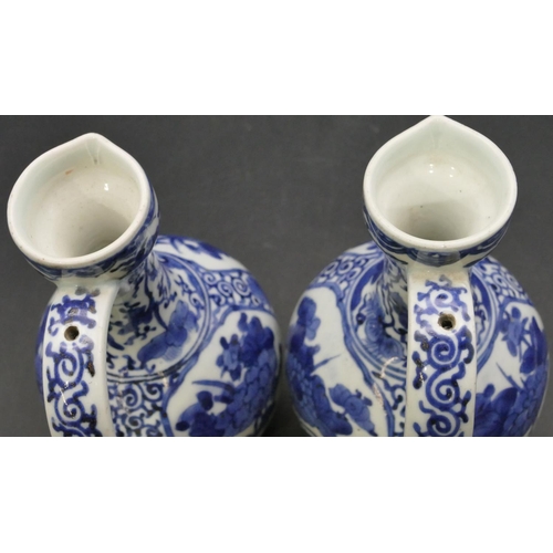 162 - A pair of Oriental blue and white bulbous thin necked jugs with allover floral, leaf and scroll deco... 