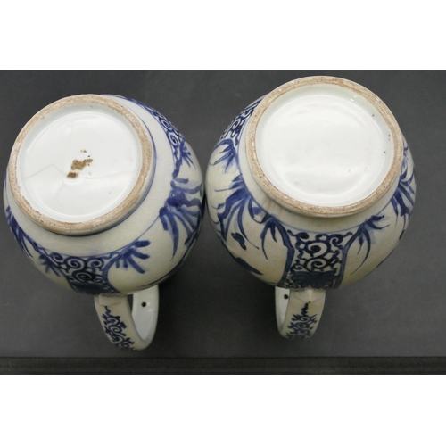 162 - A pair of Oriental blue and white bulbous thin necked jugs with allover floral, leaf and scroll deco... 