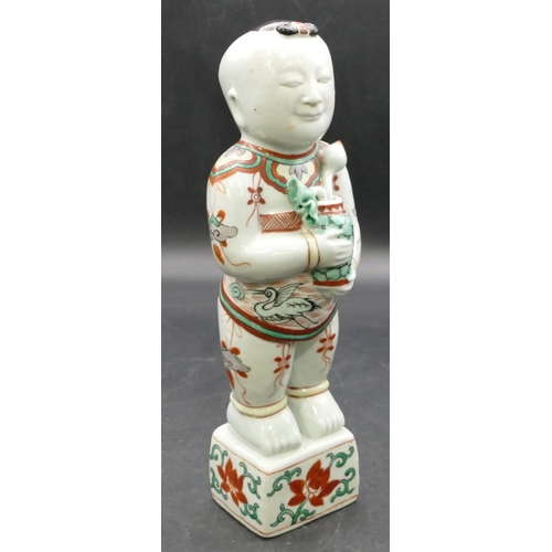 180 - A 19th Century Oriental figure of a standing gentleman holding a vase of flowers, on white, red and ... 