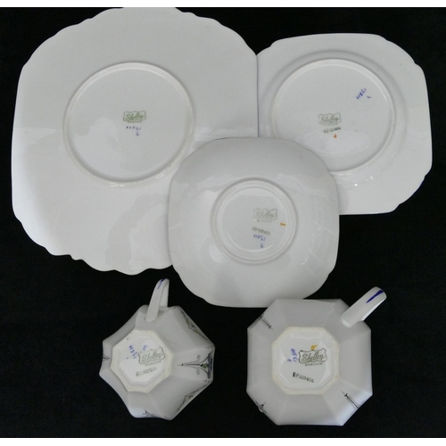 184 - A Shelley part tea service on white and blue ground with multicoloured floral, leaf and scroll decor... 