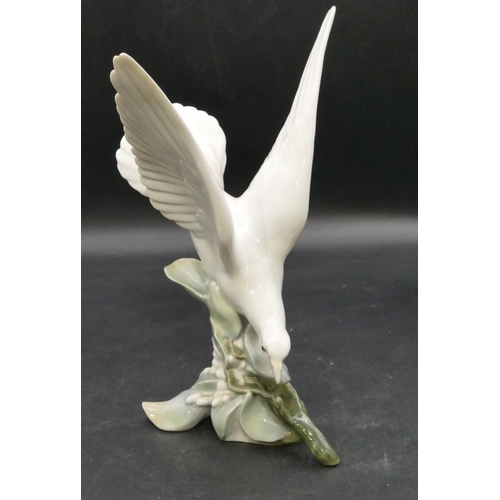 191 - A Lladro figure of a perched white bird with wings aloft, 27.5cm high