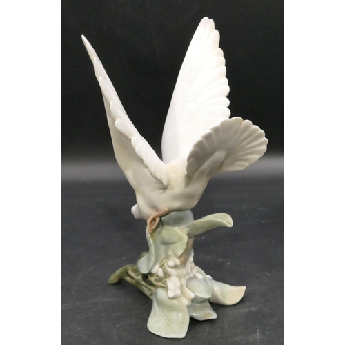 191 - A Lladro figure of a perched white bird with wings aloft, 27.5cm high