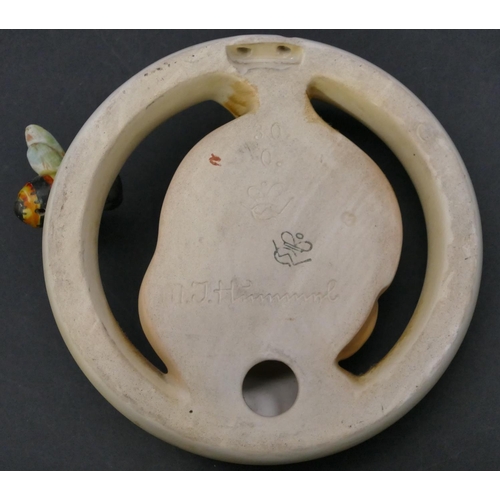 194 - A Hummel circular wall plaque with raised baby's head and bee motif, 13cm wide