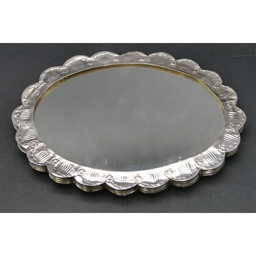 228 - An Eastern silver coloured metal oval scallop shaped hanging mirror with allover embossed decoration... 