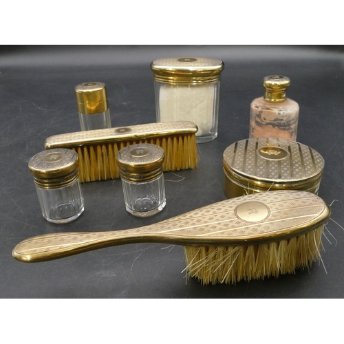 233 - A George V silver gilt travelling dressing table set, all with engine turned decoration, comprising ... 