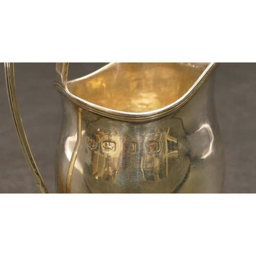 234 - An oval silver bulbous shaped cream jug with reeded rim, 10.5cm high, 3.3oz